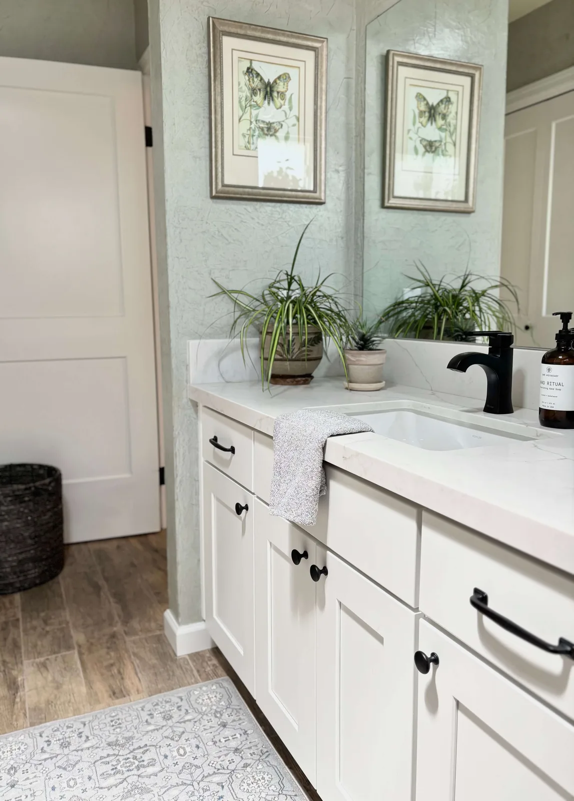 Bathroom in Folsom with quartz counters, matte black fixtures, and custom vanity styling by Designed Curated