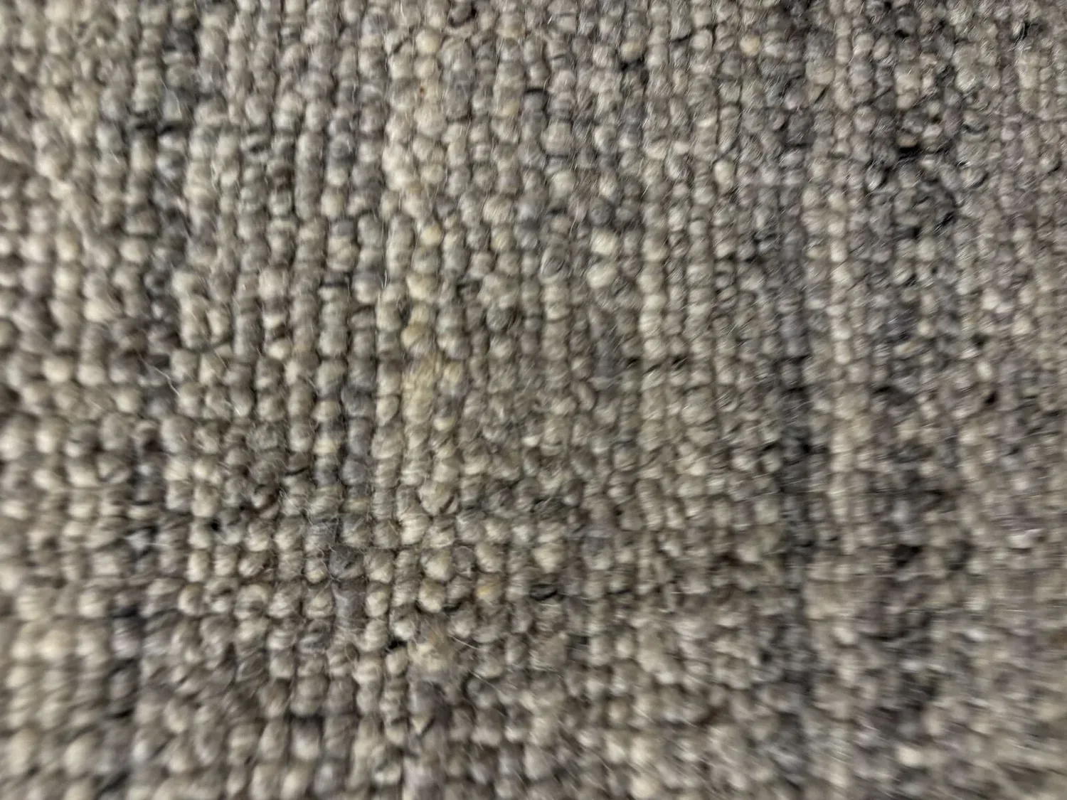 Close-up image of a textured gray carpet or rug surface