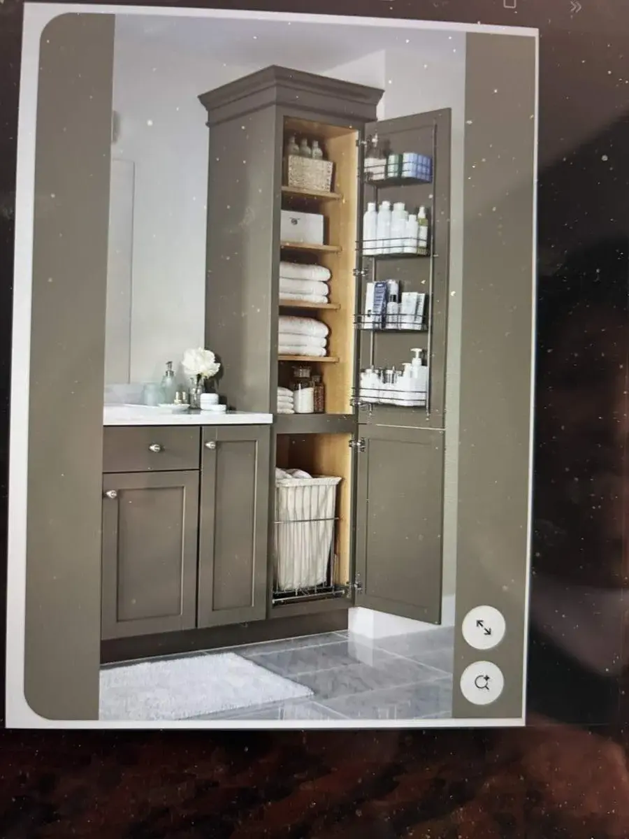 A bathroom cabinet open to show orderly towels and essentials