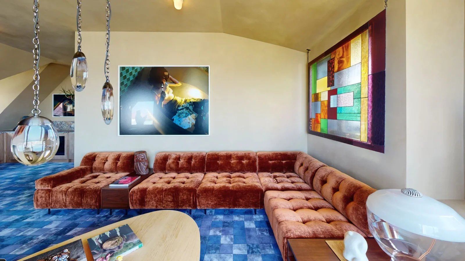 Rust velvet modular sectional on blue patterned carpet in the media lounge at the Pacific Heights showhouse