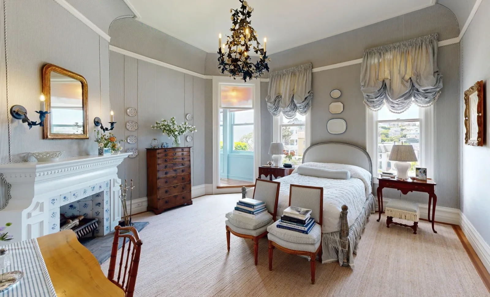 Gray striped bedroom with balloon shades, plate wall, and tiled fireplace at the 2315 Broadway showhouse